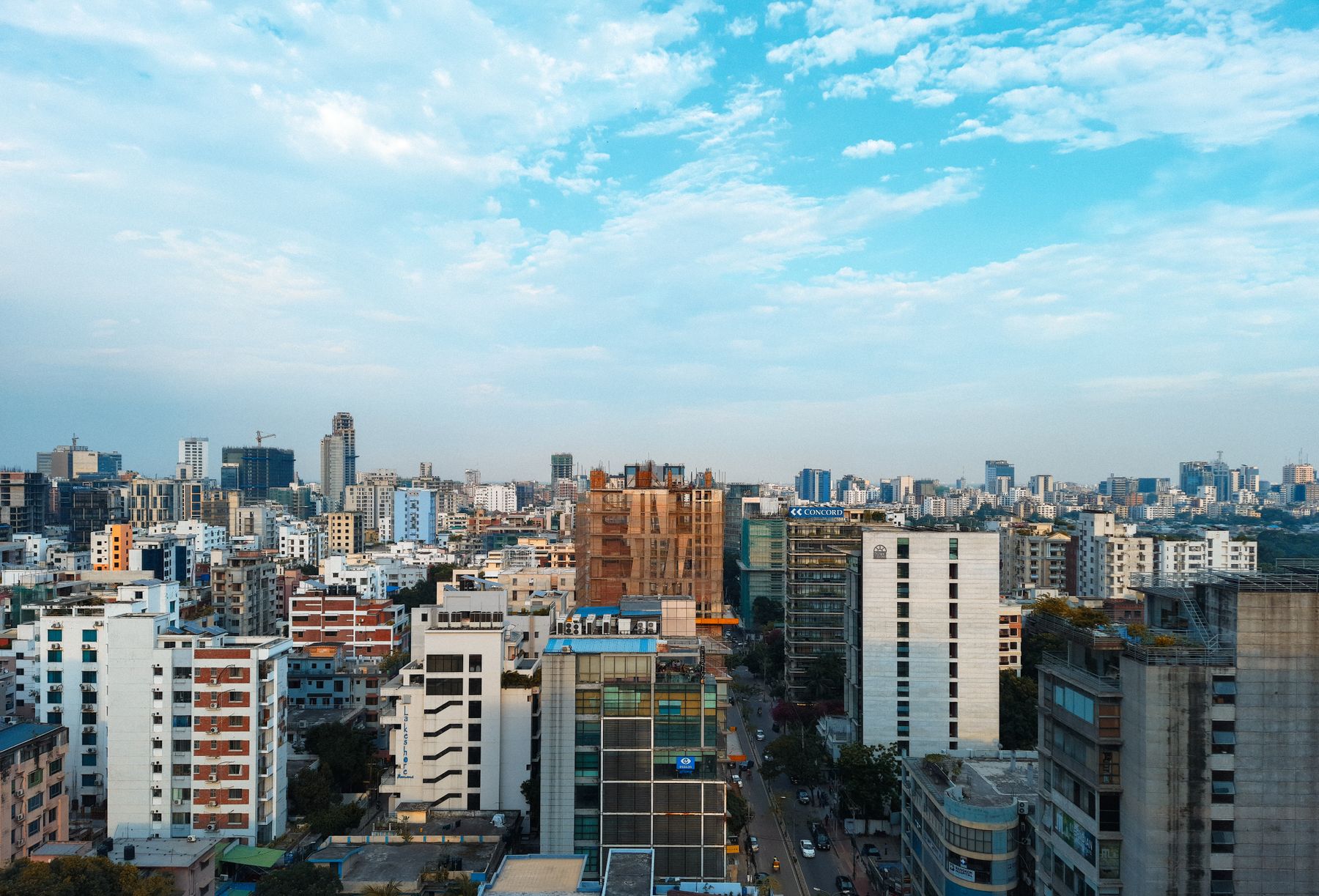 Dhaka cityscape with high-rise buildings under a blue sky