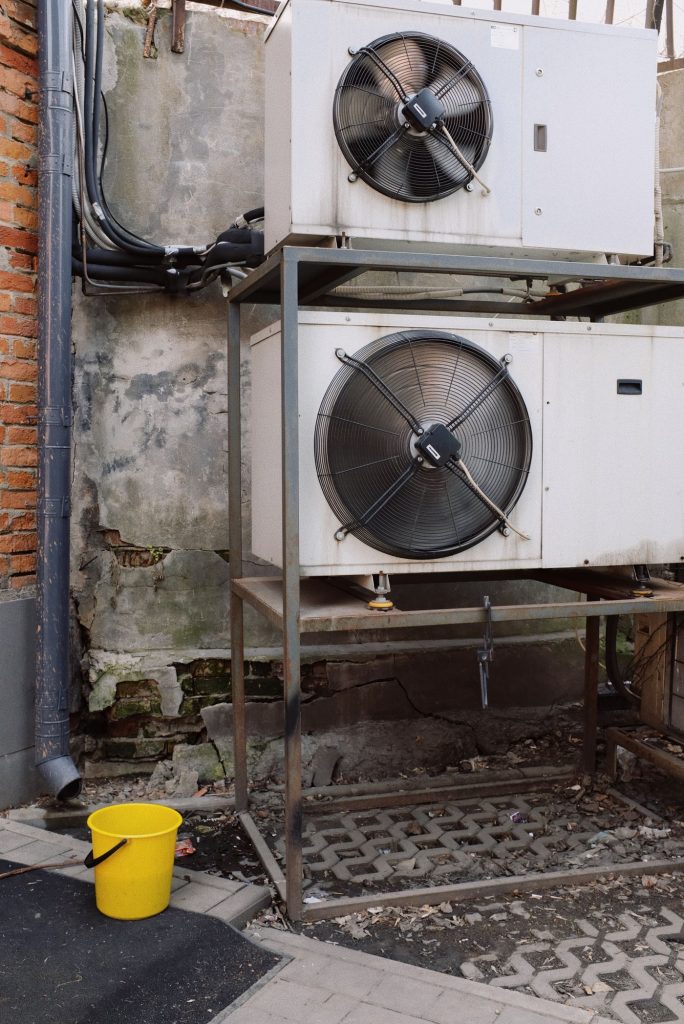 Outdoor air conditioner units installed on a metal frame outside a commercial building
