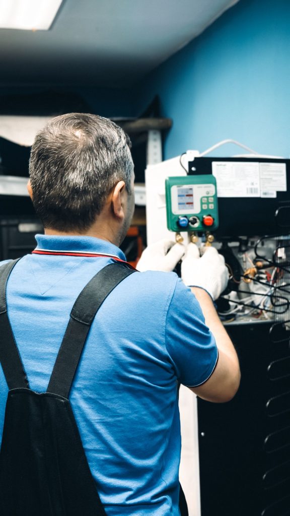 Technician carrying out maintenance on an air conditioning unit indoors