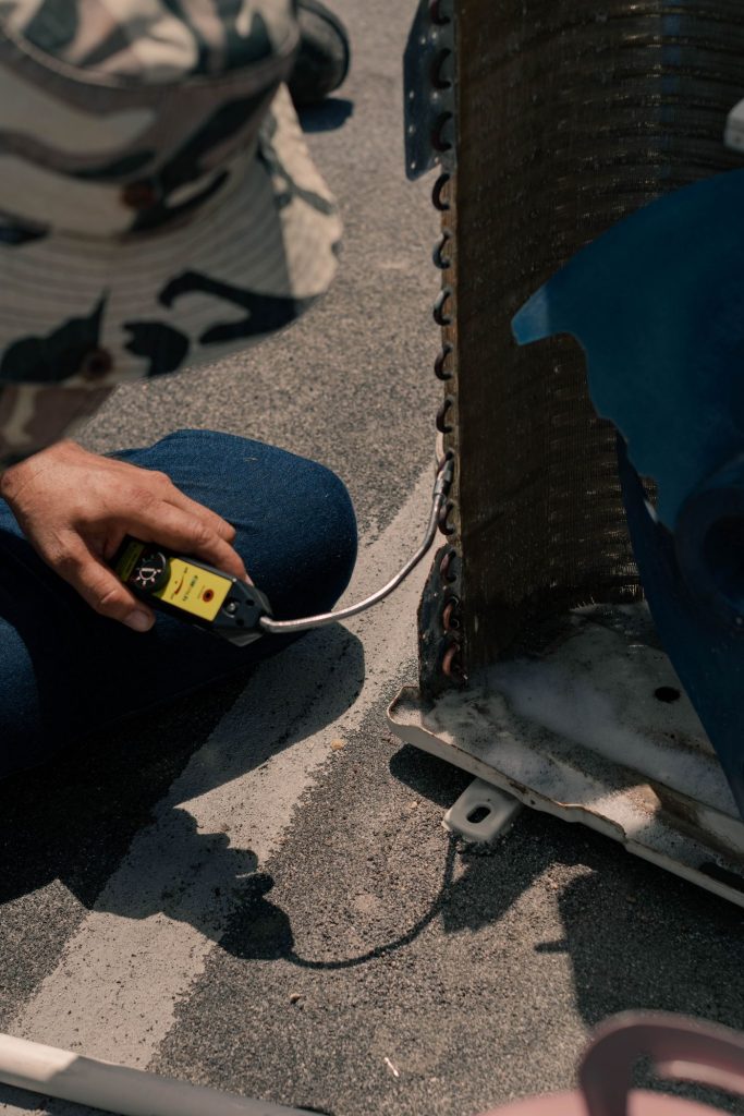 Close-up of a technician testing air conditioner wiring with a meter